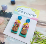 Brown kitties on rainbow background with blue tops snd pink flower