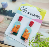 Orange kitties with red tops snd pink flower 🌸